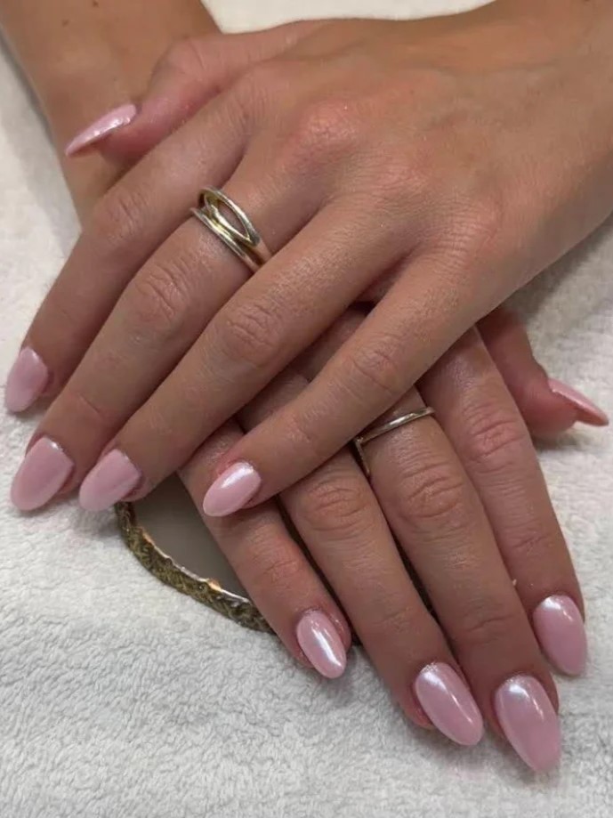 Close-up of shimmery pink BIAB manicure in a salon