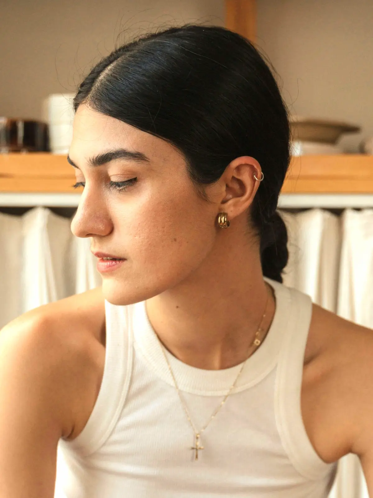Woman sitting on a stool with a hoop in her helix piercing