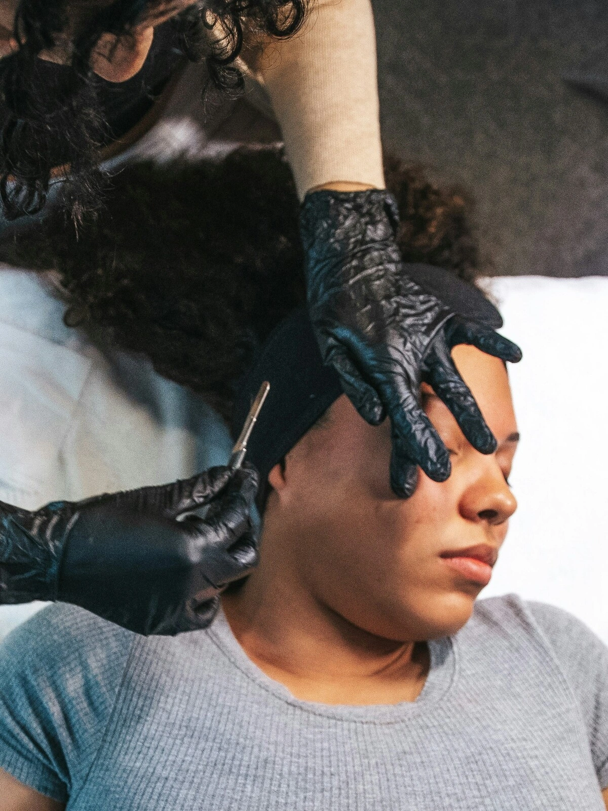 Top view of an aesthetician performing dermaplaning on a client in salon